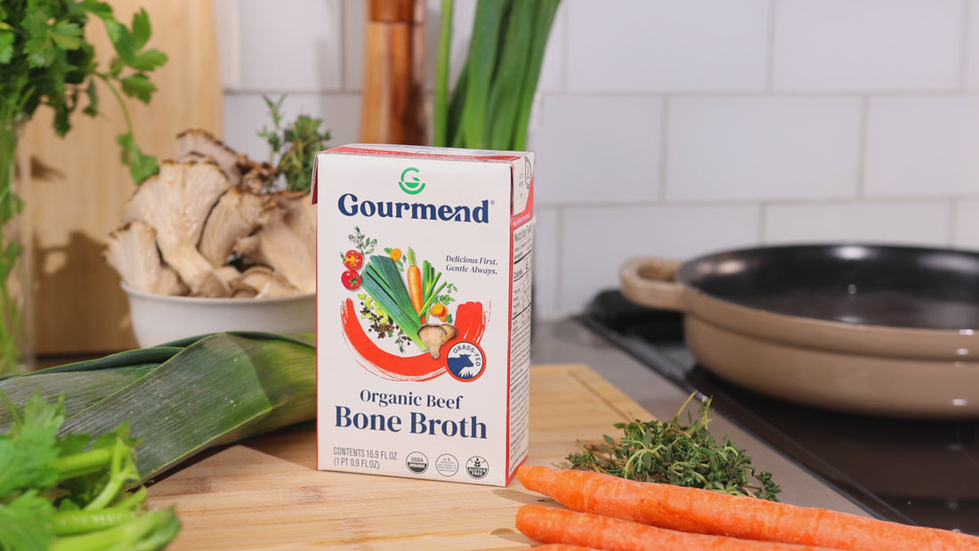 Gourmend's low FODMAP organic beef bone broth served in a bowl with fresh herbs, perfect for sipping or cooking.