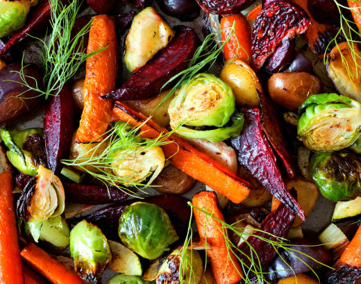 A tray of roasted vegetables — carrots, beetroot, Brussels sprouts and potatoes — scattered with fronds of dill
